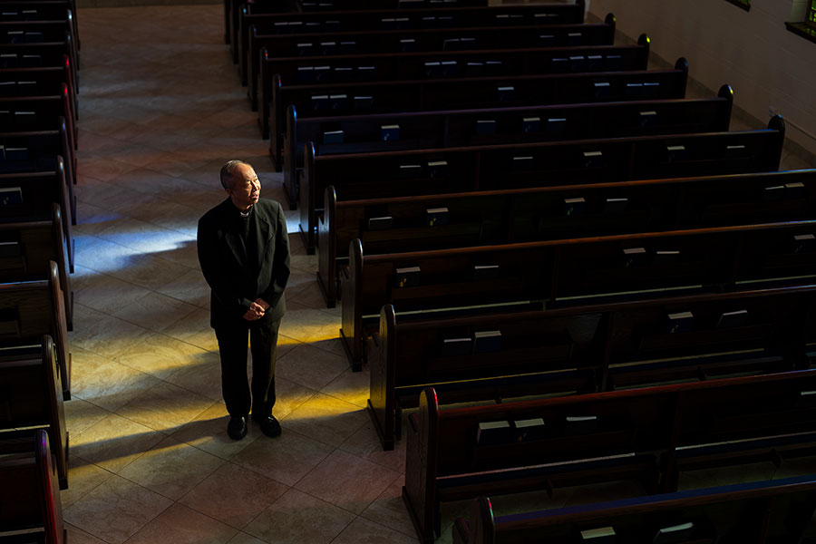 Fr. Thu walks down the aisle in his Parish hall